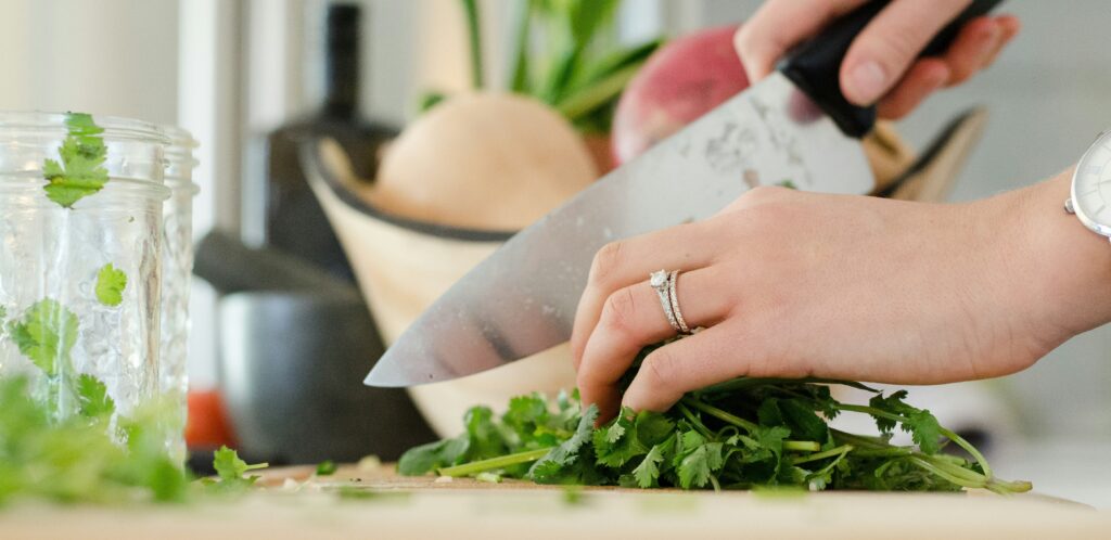 まな板の上のパクチーを包丁で切っています