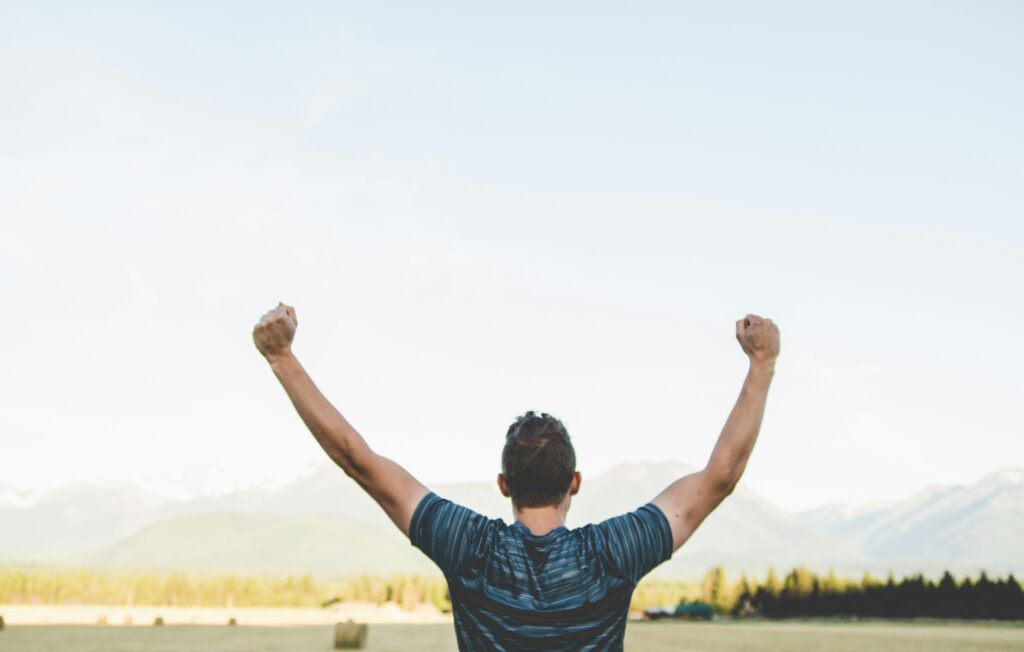 男性が両手を挙げて喜んでいます