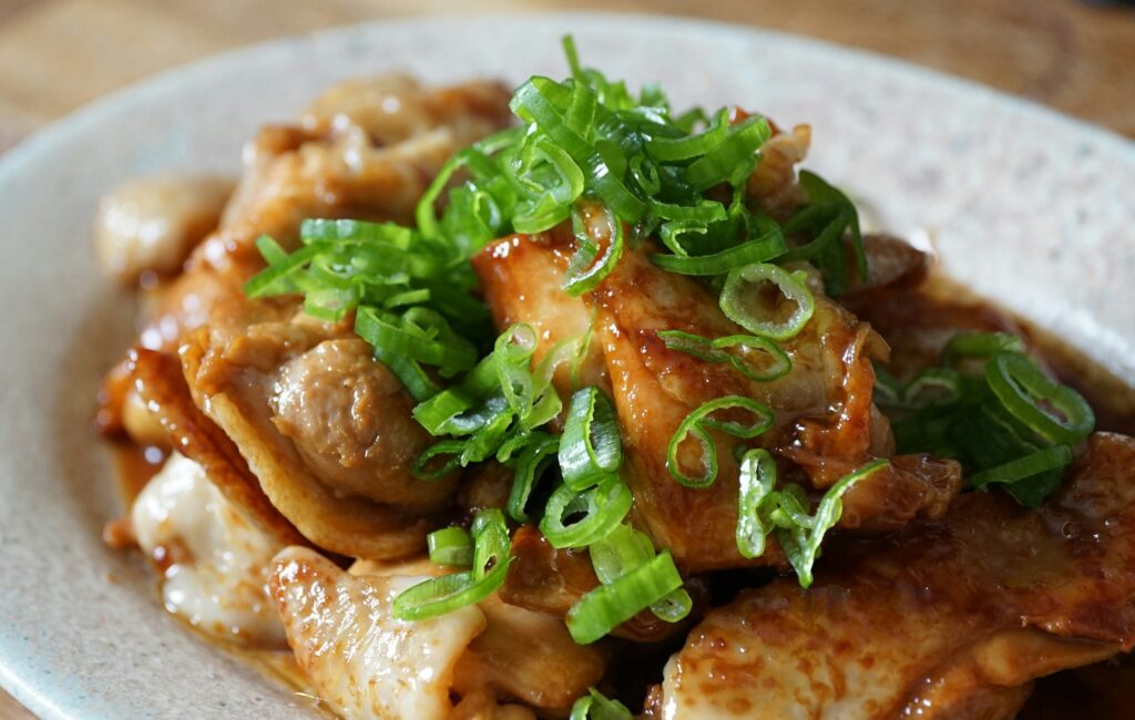 鶏肉の照り焼きが白い皿に盛られている