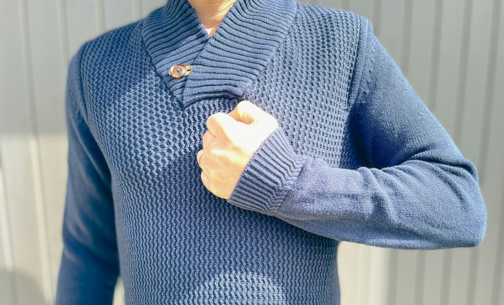 男性が左手の拳を胸の前にあてています