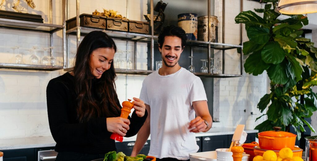 男女が楽しそうに料理をしています