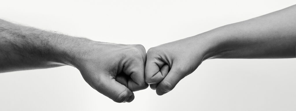 女性と男性がグータッチをしています