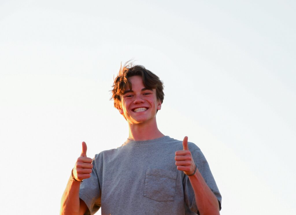 両手でグッドサインをしている笑顔の男性