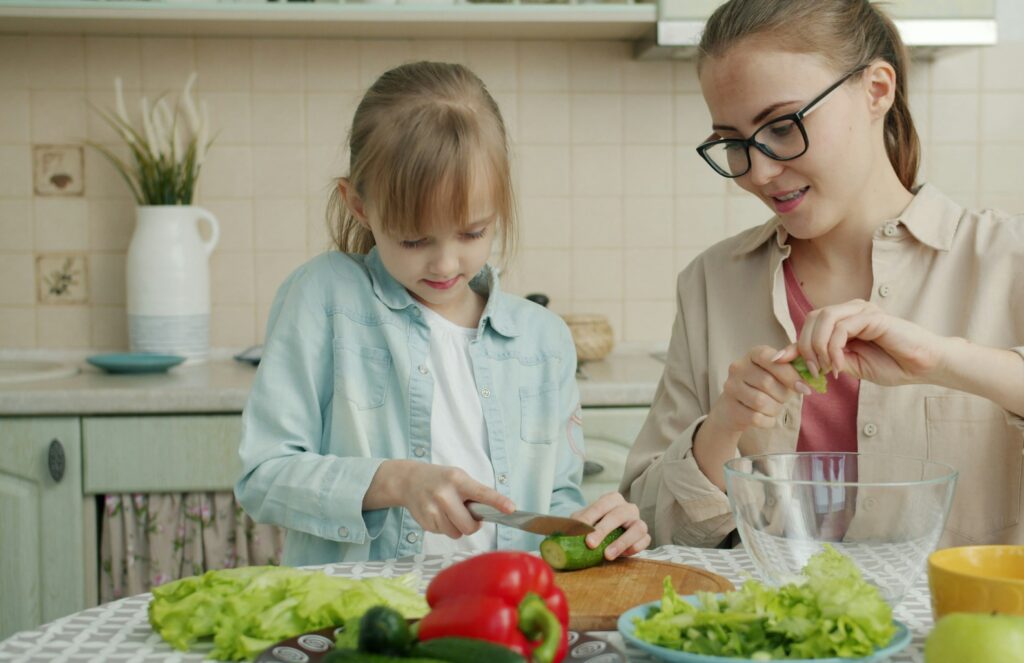 女の子と母親が一緒に料理をしています