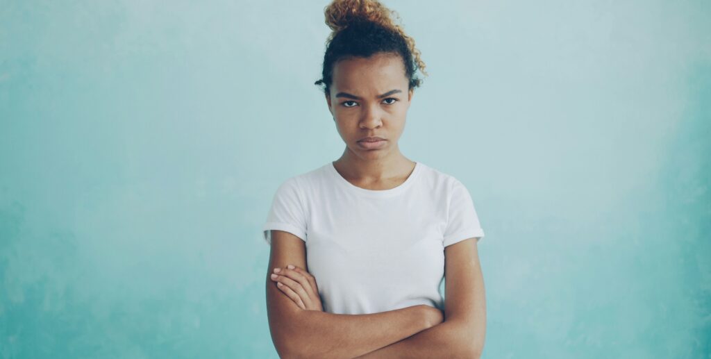 女性が腕組みをして不満そうな表情を浮かべています