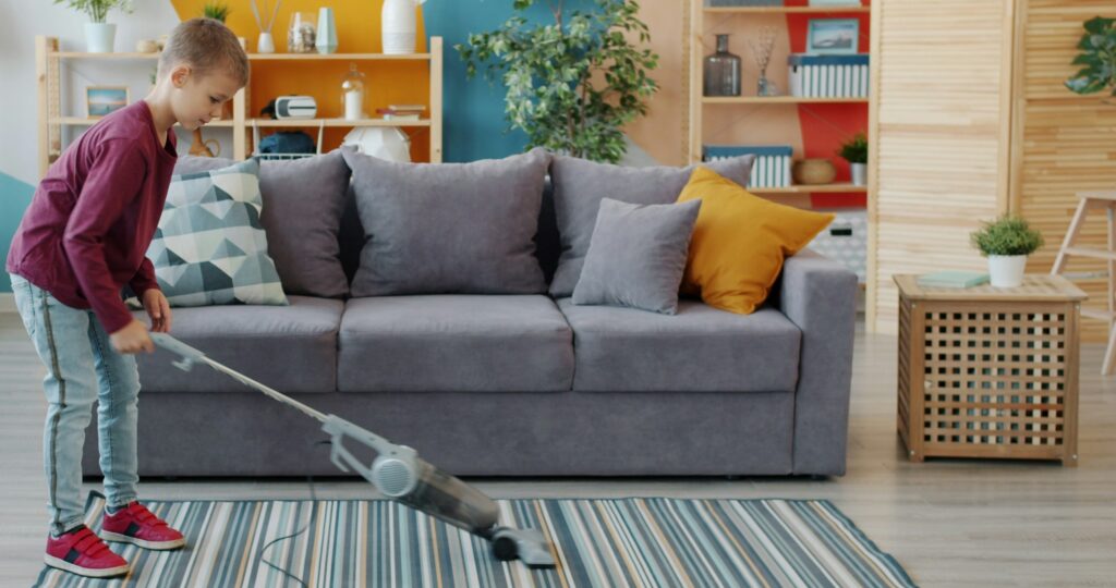 子供がリビングで掃除機をかけている